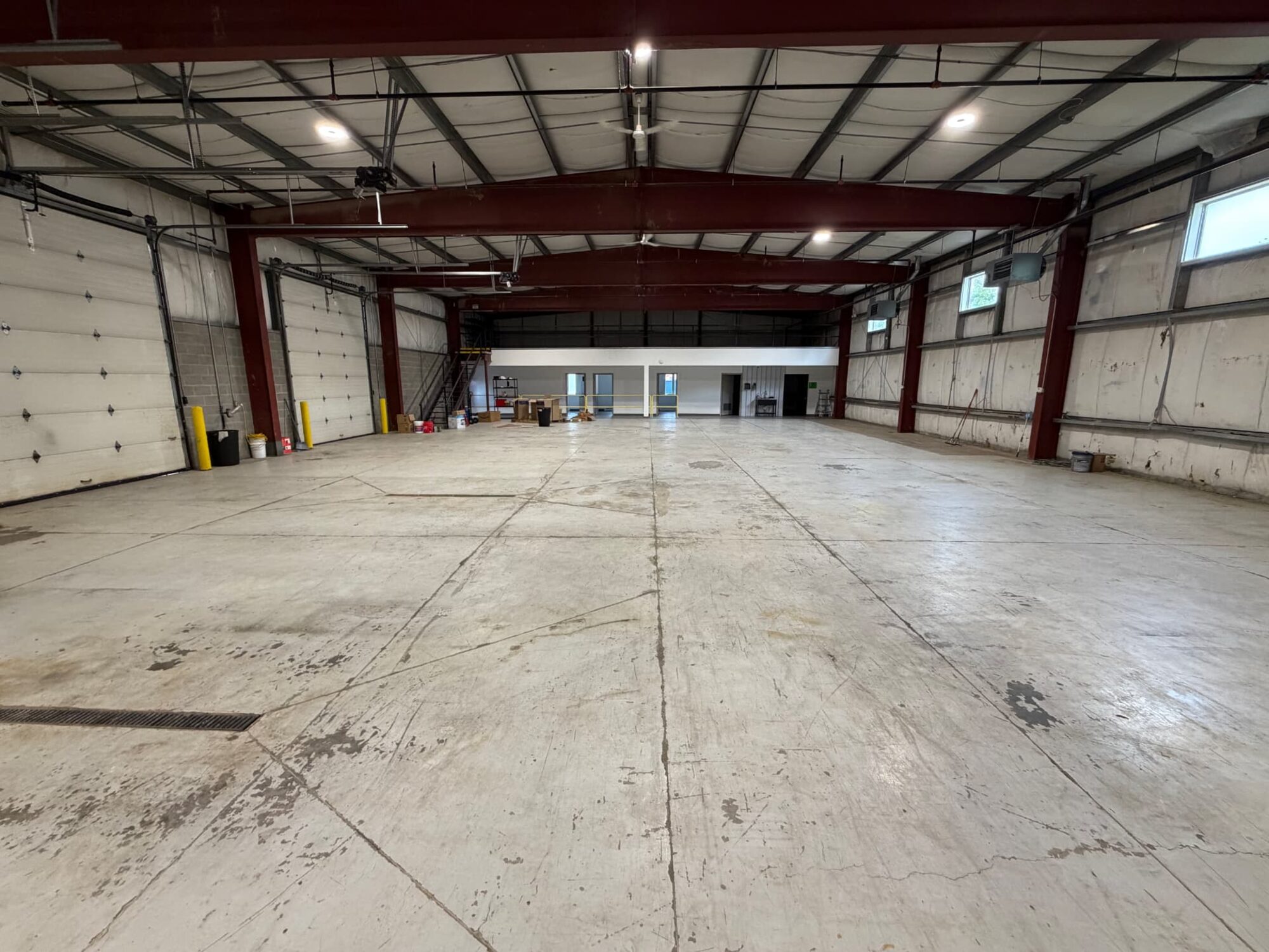 The unfinished Fitness Artist flagship: open concrete floor under exposed steel framing
